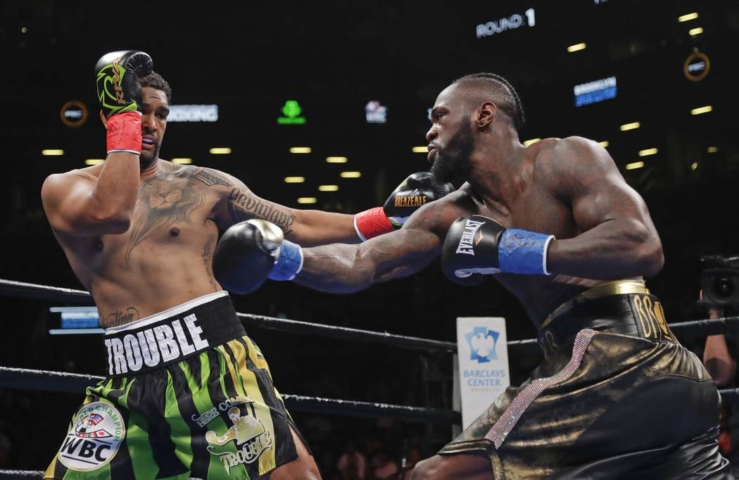 Dominic Breazeale, left, evades a right from Deontay Wilder during the first round of the WBC h ...