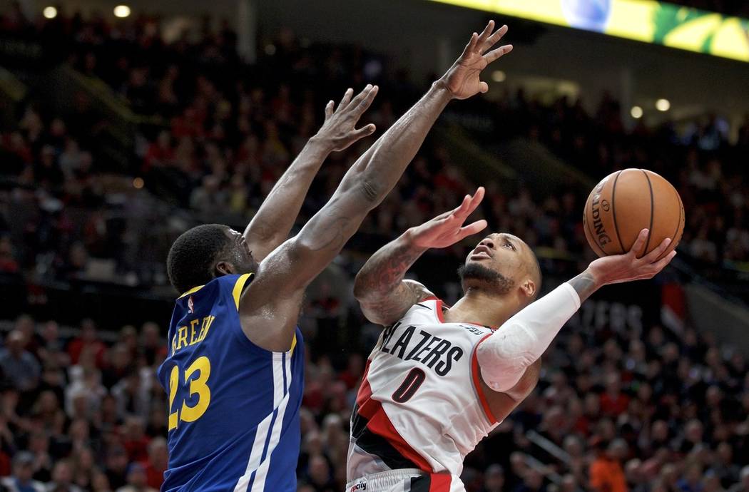 Portland Trail Blazers guard Damian Lillard, right, shoots over Golden State Warriors forward D ...