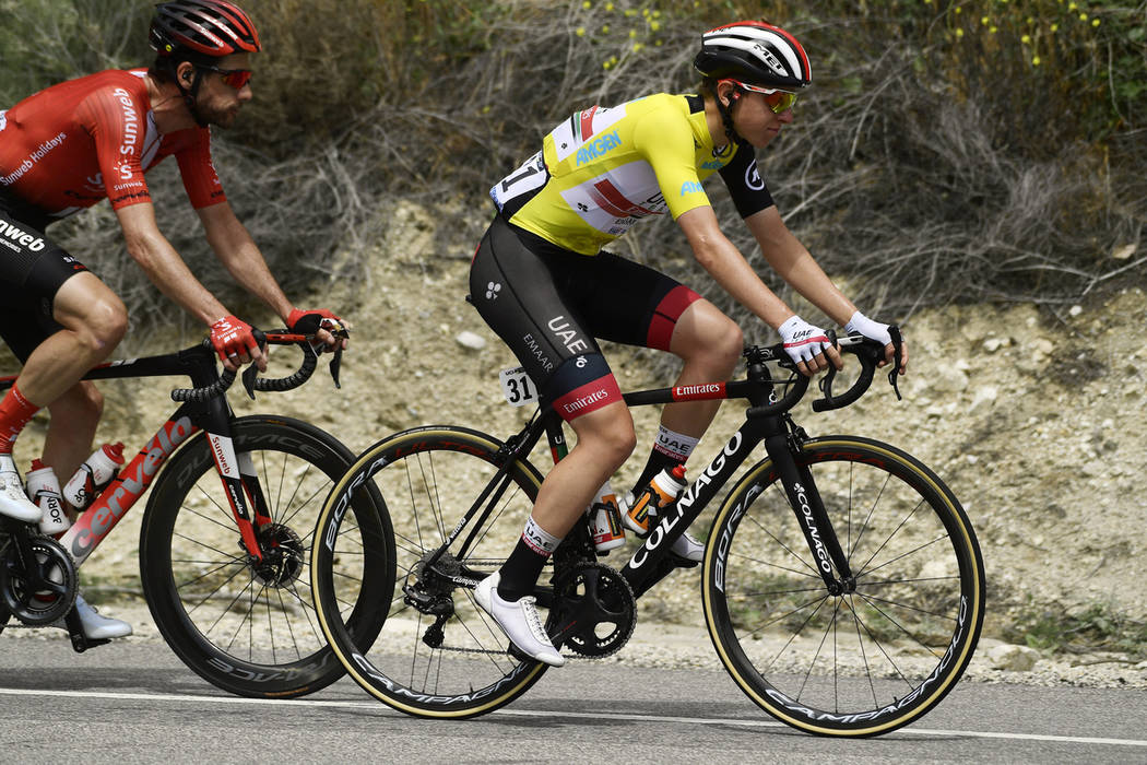 Tadej Pogacar, right, of Slovenia, rides along with the peloton during the seventh and final st ...