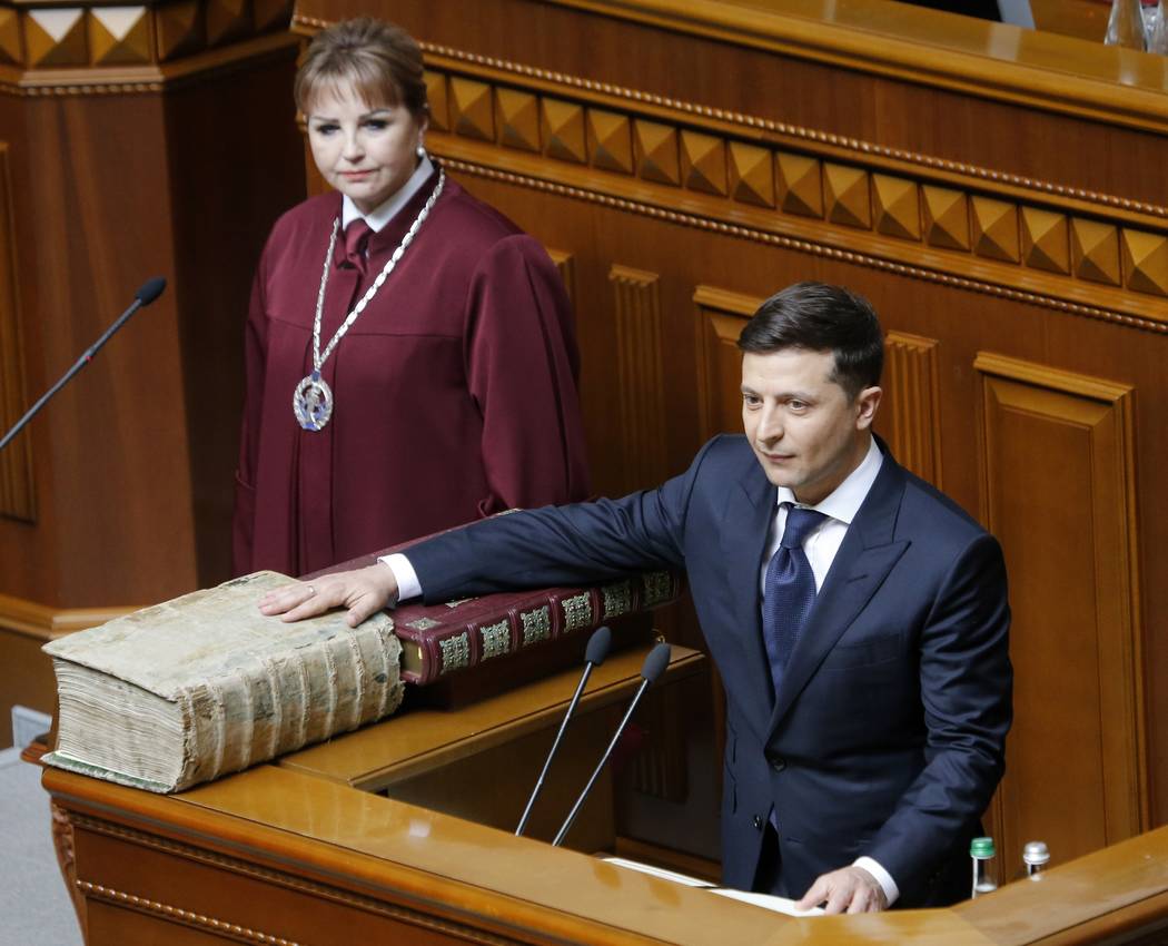 Ukrainian President-elect Volodymyr Zelenskiy swears on the Bible as he takes the oath of offic ...