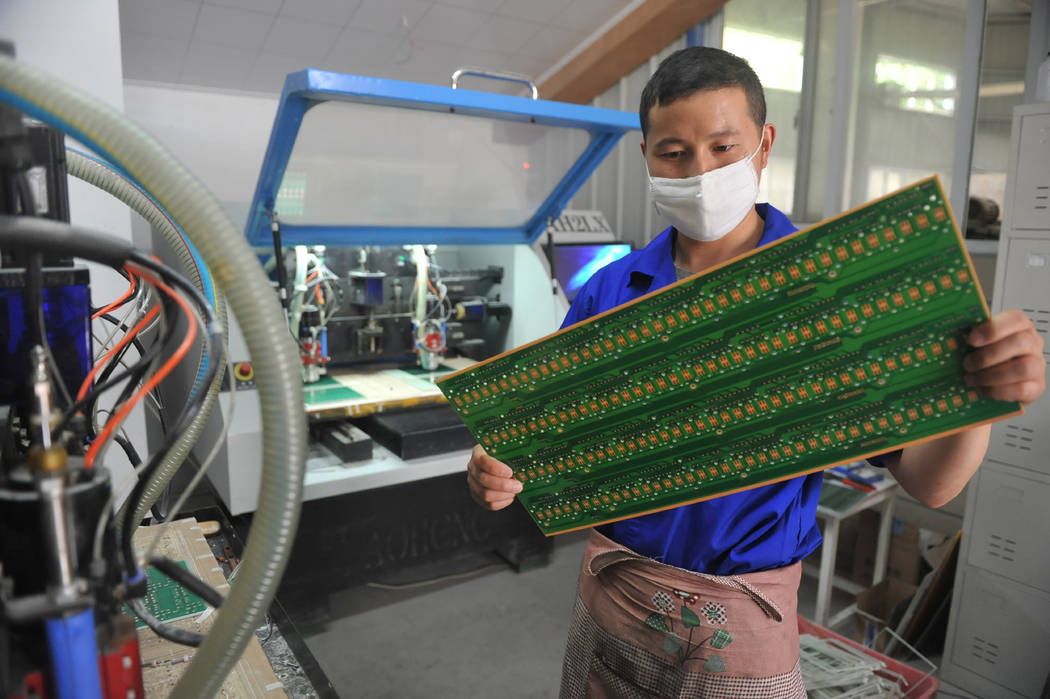 A staff member works in a circuit board manufacturing facility May 22, 2018, in Hangzhou in eas ...