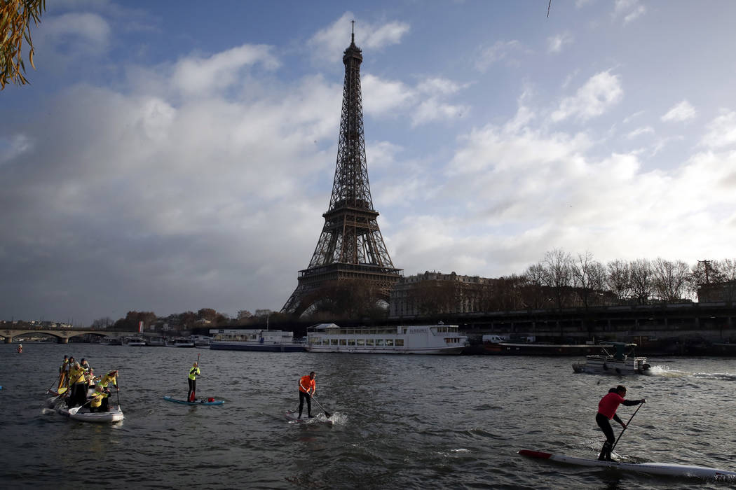 In this Dec.9, 2018 file photo, competitors paddle on the Seine river in front of the Eiffel To ...