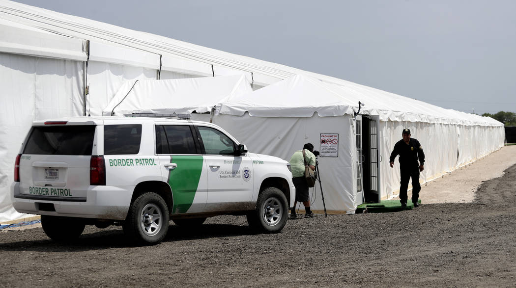 A security guard enters a new U.S. Customs and Border Protection temporary facility near the Do ...