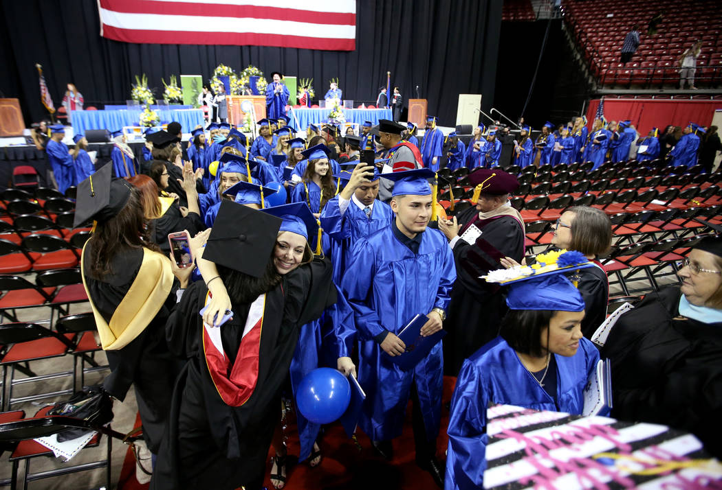 Graduate Brianna Marberry hugs professor Sheena Guynn during the rescessional during College of ...