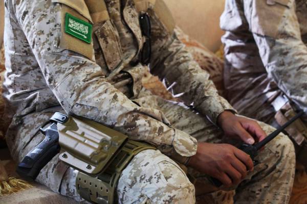 FILE - In this Nov. 28, 2018, file photo, an armed Saudi soldier holds a walkie-talkie near Muk ...