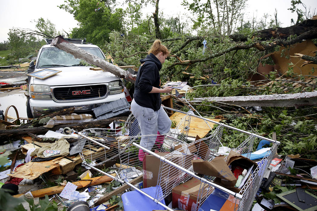 Michelle Underwood searches through the wreckage of a feed store where she stored most of her b ...