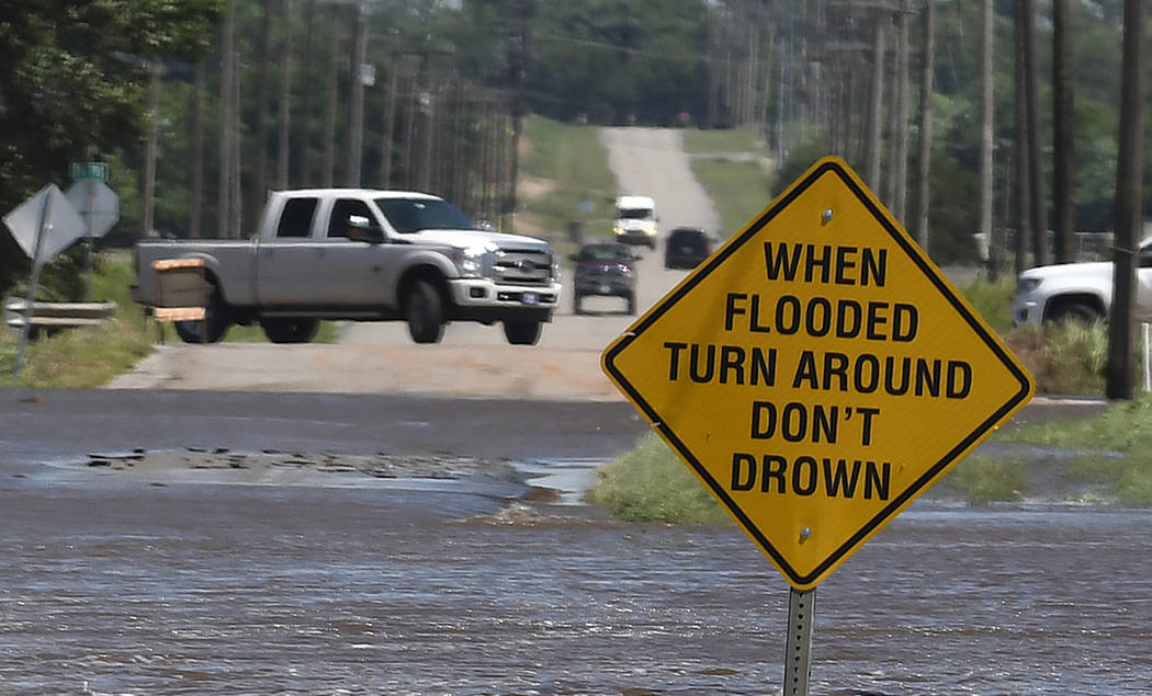 Traffic turns around as flood water covers 13th street in Kingfisher, Okla., Tuesday, May 21, 2 ...