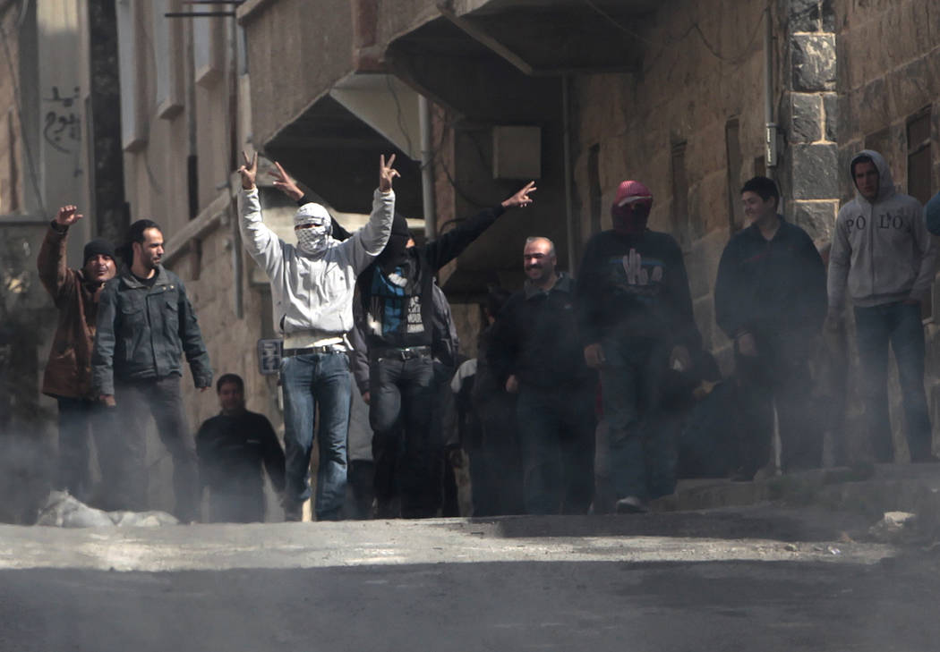 FILE - In this March 23, 2011 file photo, anti-Syrian government protesters flash Victory signs ...