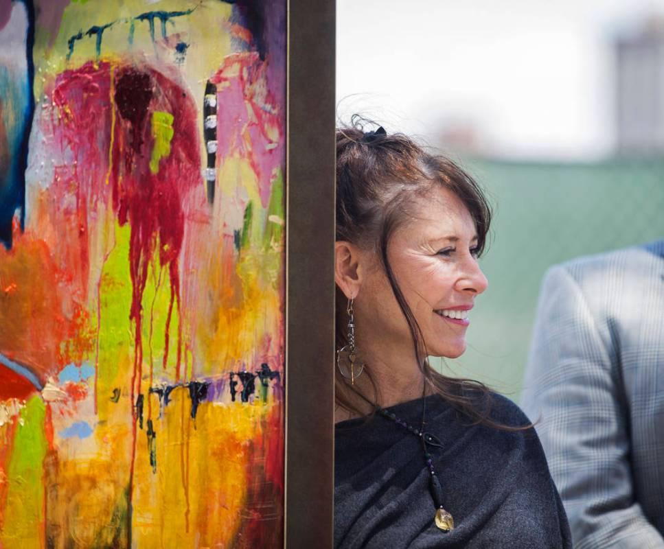 Artist Niki Sands stands next to one of her paintings during a ground breaking ceremony for the ...