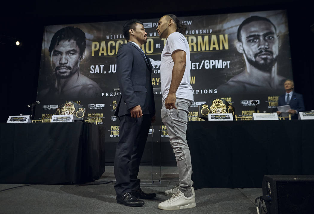 Manny Pacquiao, left, and Keith Thurman stand face to face during a news conference, Tuesday, M ...