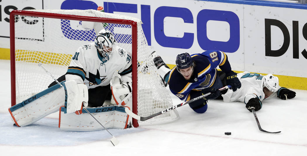 St. Louis Blues center Robert Thomas (18) falls as he chases the puck between San Jose Sharks g ...