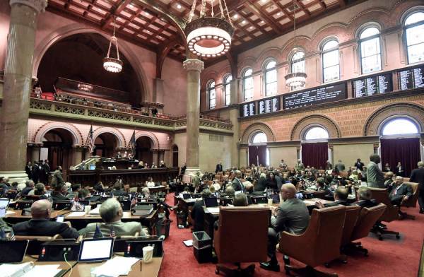 Members of the New York state Assembly vote on legislation that authorizes state tax officials ...
