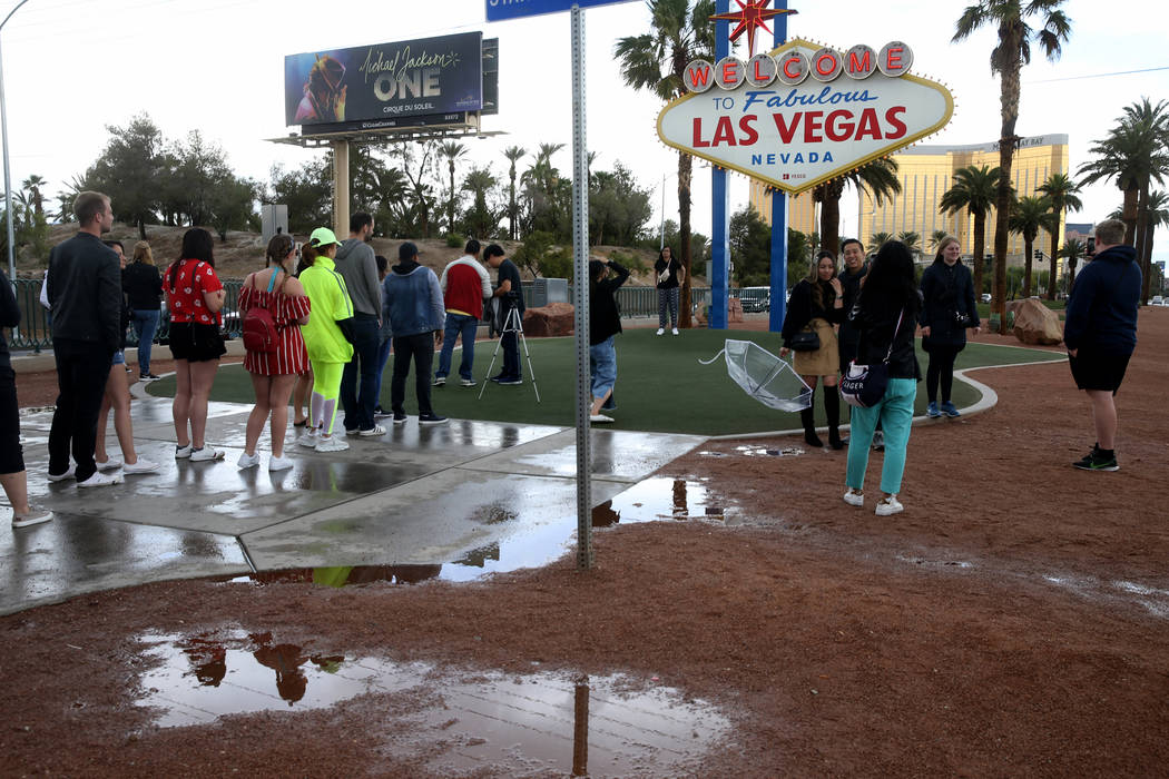 Arisa Pinitratthapol, holding umbrella, and Greg Ow, of Los Angeles, get their photo taken by R ...