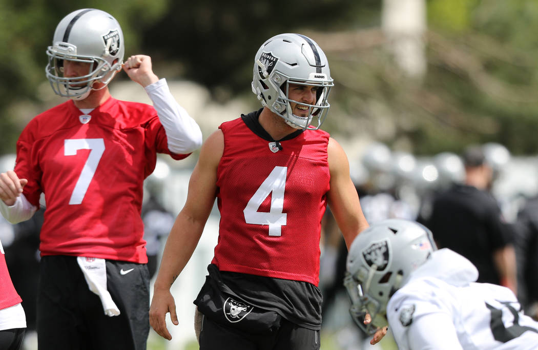 Oakland Raiders quarterback Derek Carr (4) walks on the field next to quarterback Mike Glennon ...