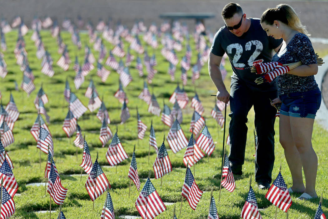 Volunteers Hannah Mehlhaff, right, and a man who declined to give his name, assist with placing ...