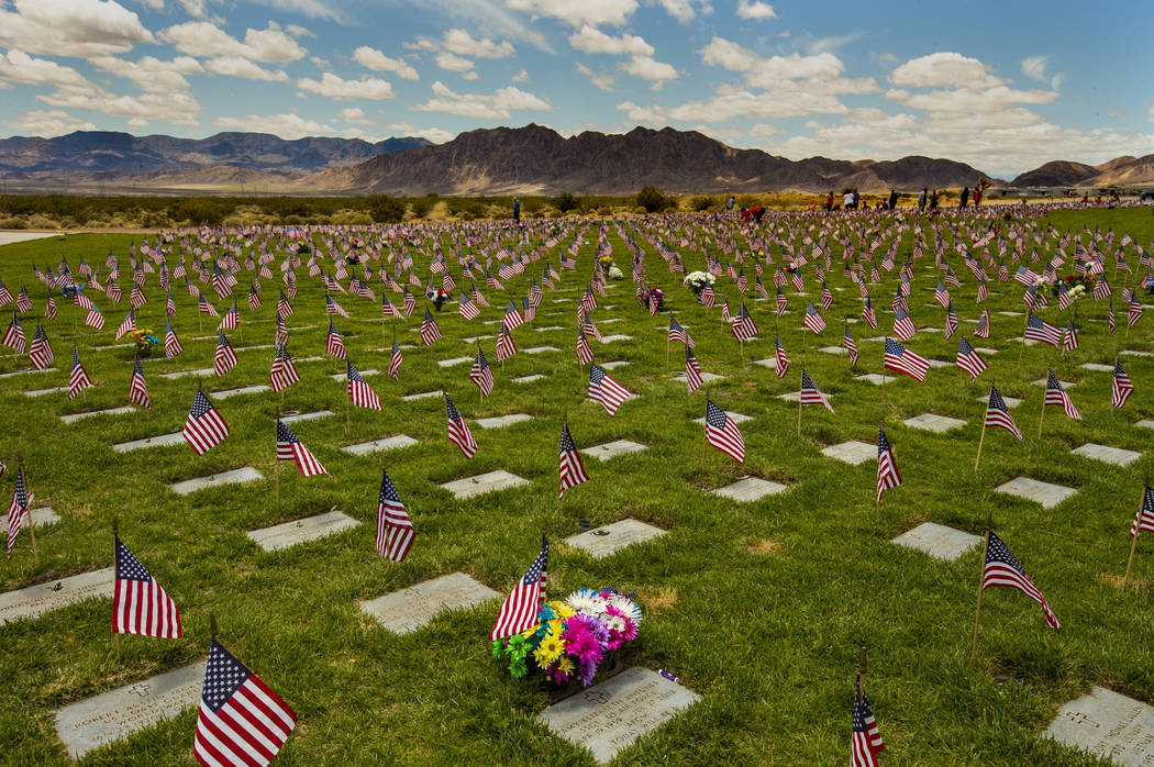 Flags line each gravesite as visitors wander about at the Southern Nevada Veterans Memorial Cem ...