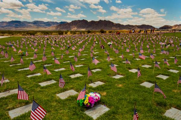 Flags line each gravesite as visitors wander about at the Southern Nevada Veterans Memorial Cem ...