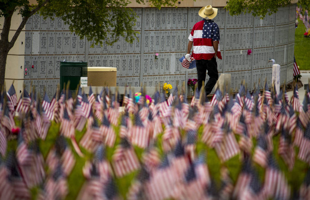 A visitor in a flag-designed shirt pays tribute during Memorial Day before a ceremony at the So ...