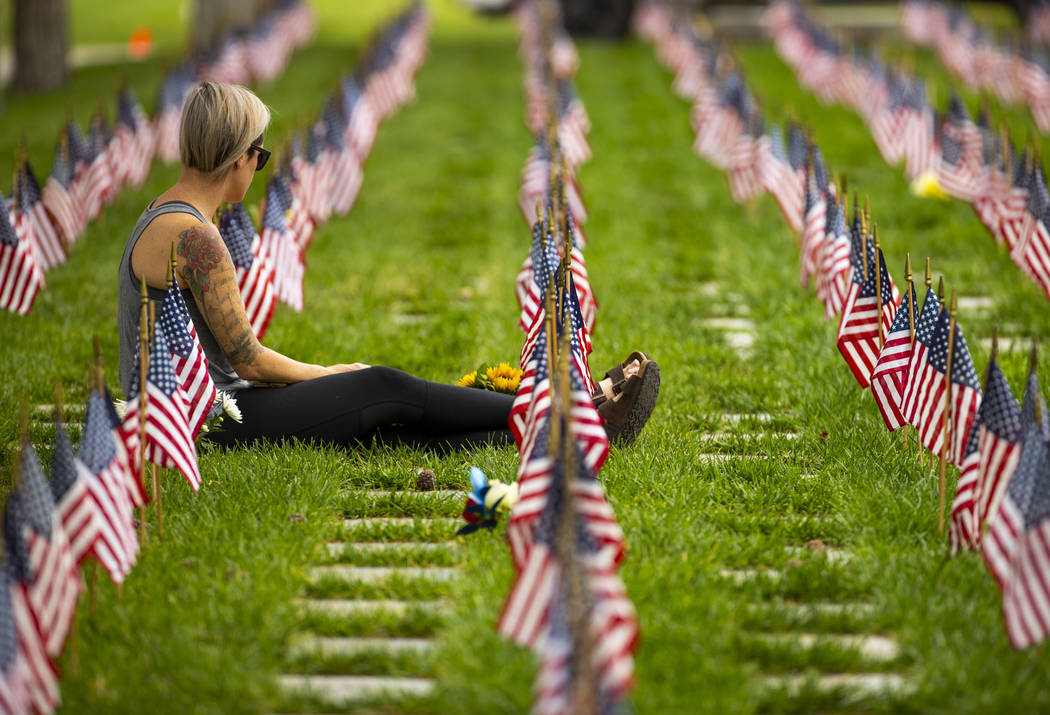 A visitor pays tribute during Memorial Day before a ceremony at the Southern Nevada Veterans Me ...