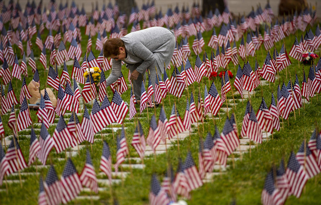 Cecelia Rivera lays flowers at the grave of her father Norman Mitchell on Memorial Day before a ...