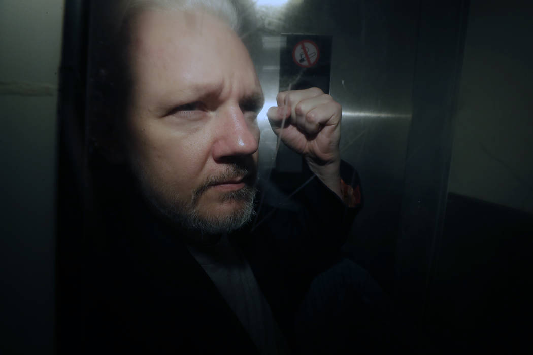 FILE - In this May 1, 2019, file photo, WikiLeaks founder Julian Assange puts his fist up as he ...