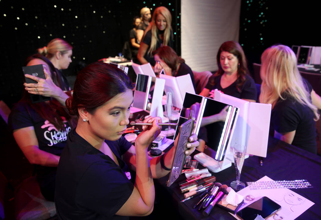 Marianne Tanada of Henderson applies makeup during a preview of Showgirl Bootcamp at Saxe Theat ...