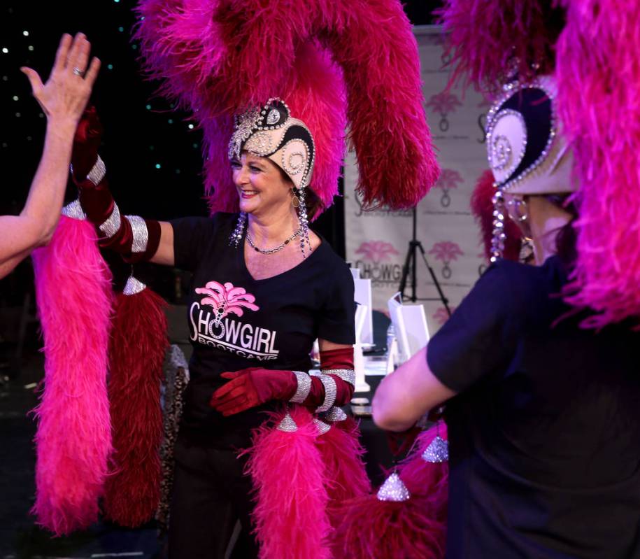 Marla Laughlin of Las Vegas gets a high-five after doing the showgirl walk during a preview of ...