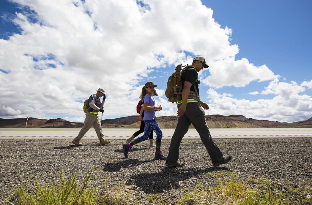 Navy veteran Jelani Hale, of Las Vegas, right, walks with daughter Jet, 9, center, and retired ...