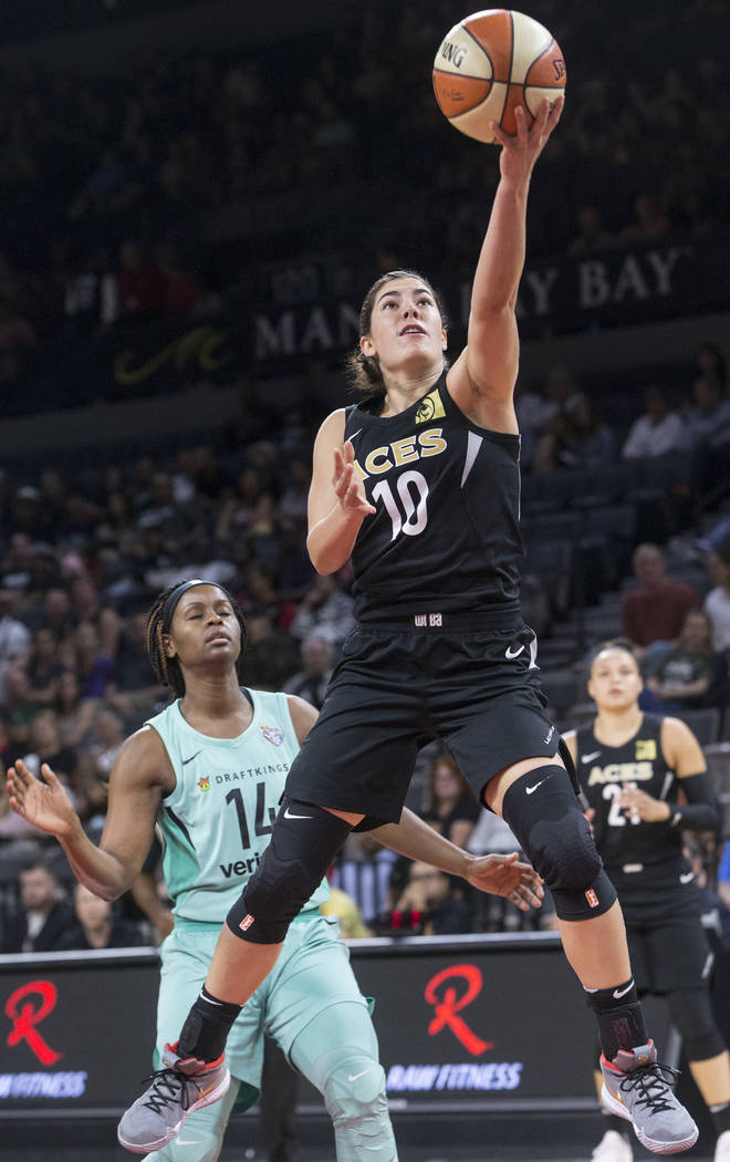 Aces guard Kelsey Plum (10) drives past New York Liberty guard Sugar Rodgers (14) in the first ...