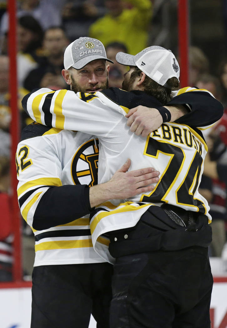 Boston Bruins' David Backes, left, hugs Jake DeBrusk (74) following Game 4 of the NHL hockey St ...