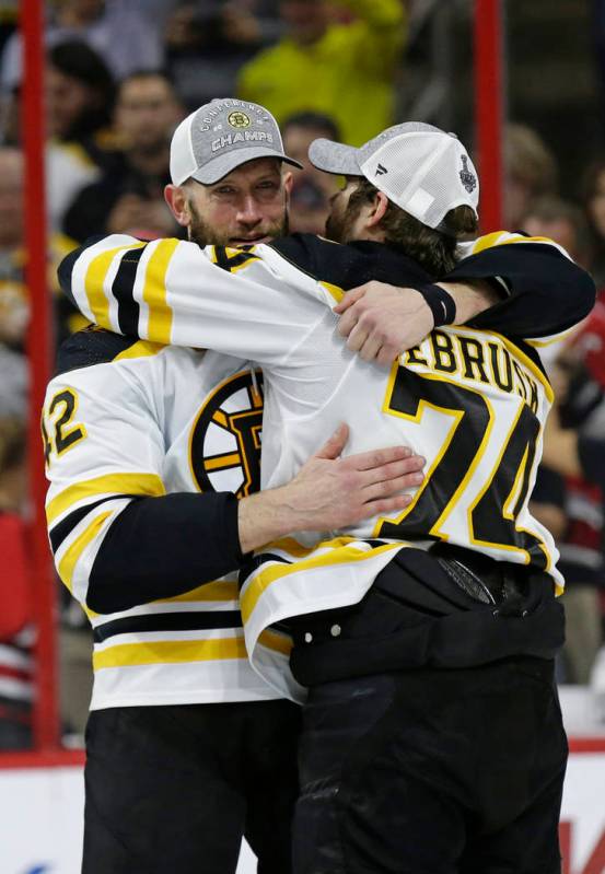 Boston Bruins' David Backes, left, hugs Jake DeBrusk (74) following Game 4 of the NHL hockey St ...