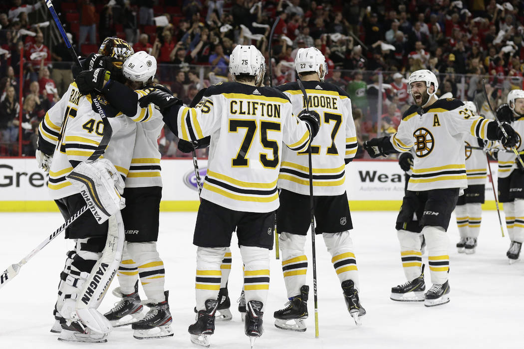 Boston Bruins goalie Tuukka Rask, left, of Finland, is congratulated by teammates following Gam ...