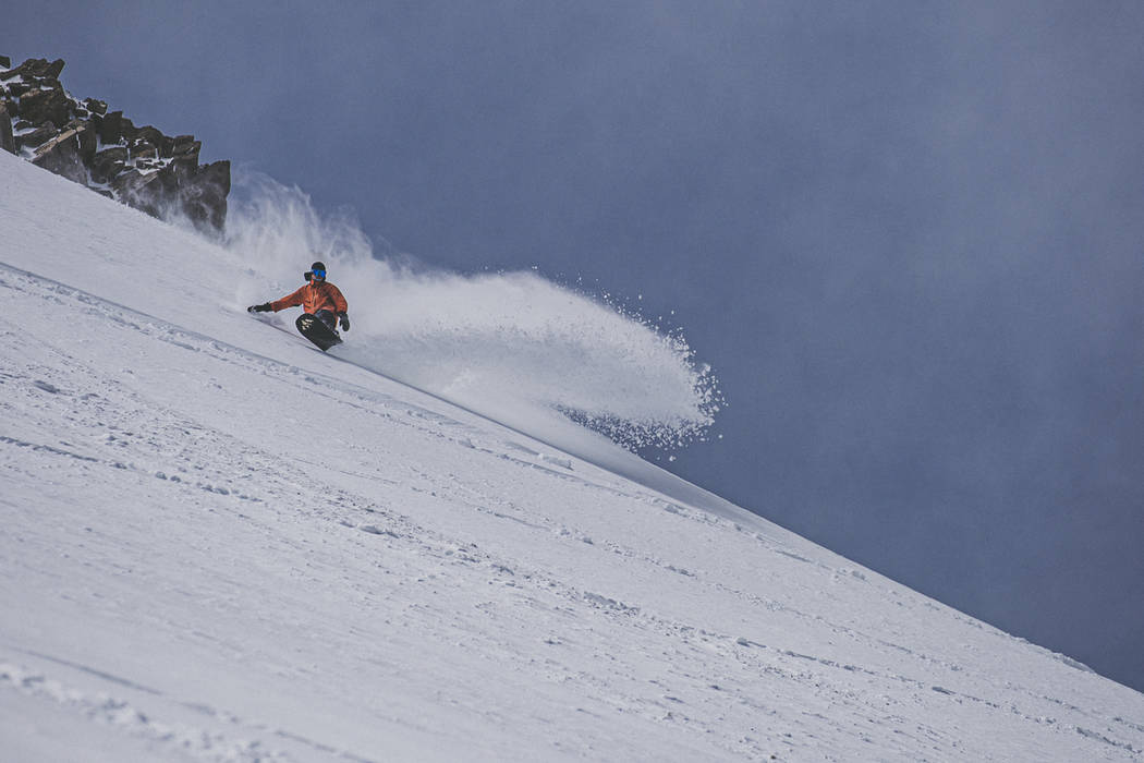 A snowboarder makes his way downhill in fresh snow at Mammoth Mountain ski area on May 17, 2019 ...