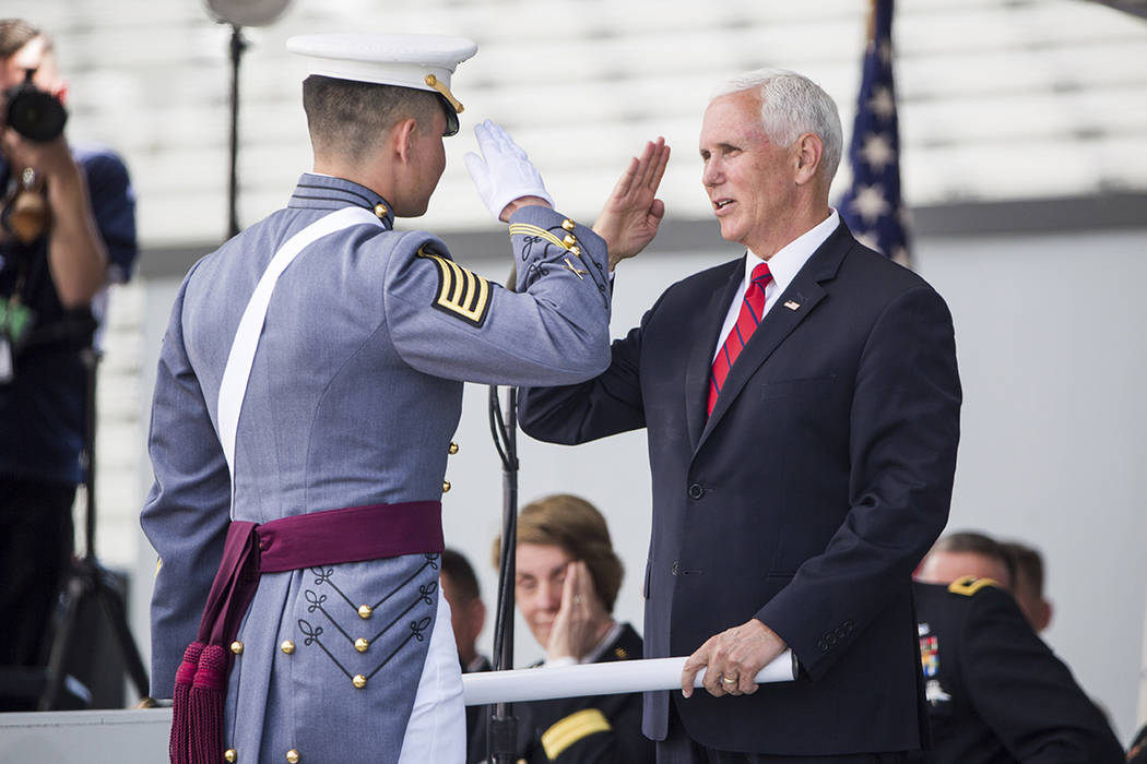 Vice President Mike Pence salutes a graduating cadet before handing him his diploma during grad ...