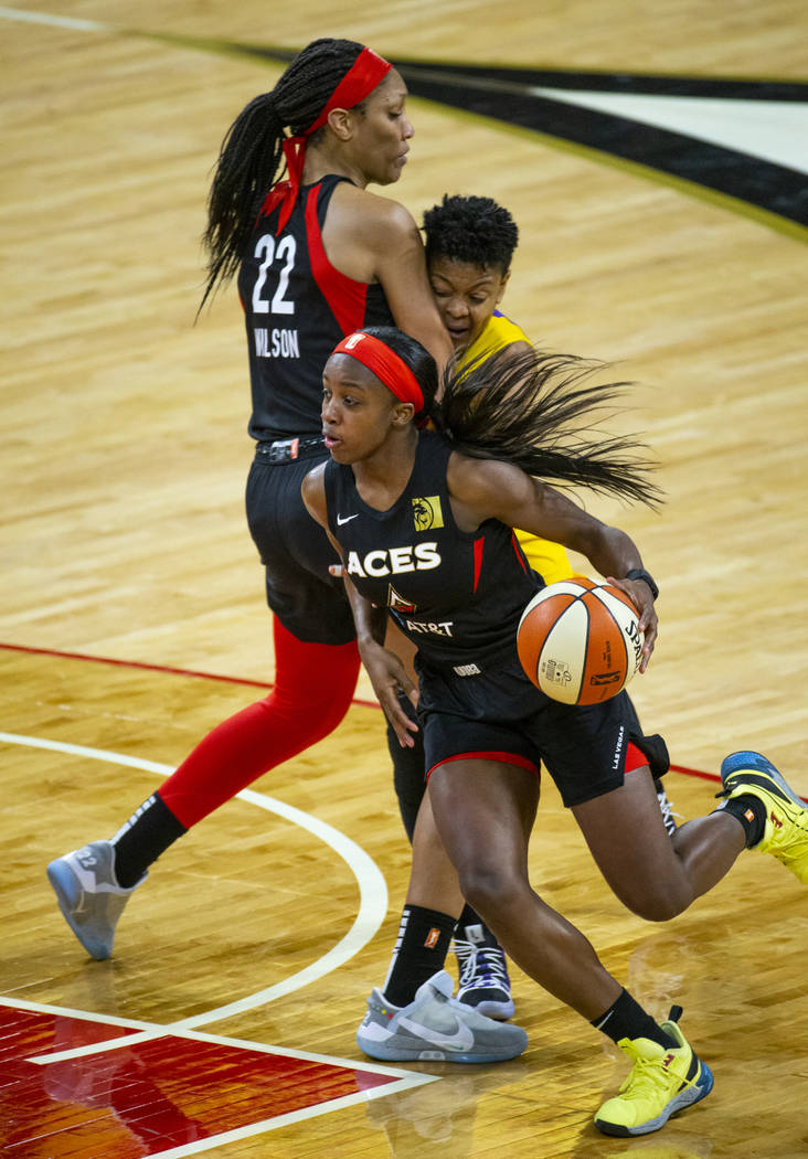 Las Vegas Aces guard Jackie Young (0) drives t6he lane past a pick by teammate center A'ja Wils ...