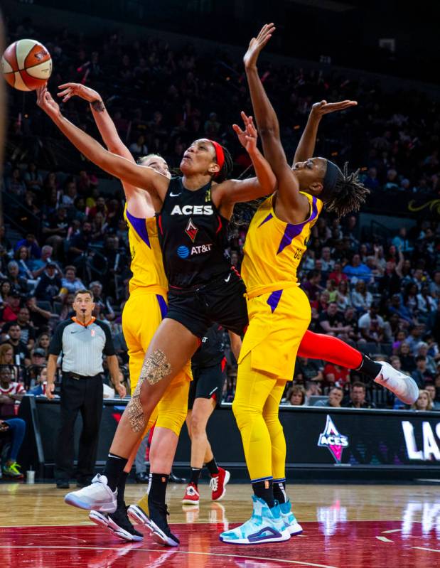 Las Vegas Aces center A'ja Wilson (22) splits the defense of Los Angeles Sparks forward/center ...