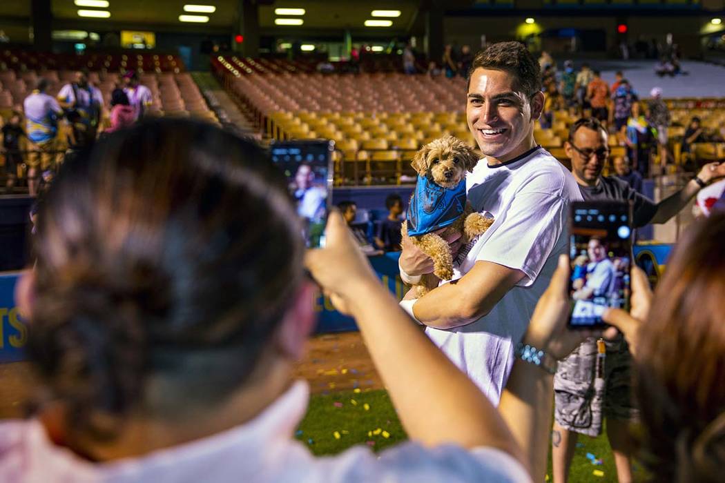 Las Vegas Lights FC goalkeeper Thomas Olsen (1) poses with dog Nessie for fan Ruby Castillo fol ...