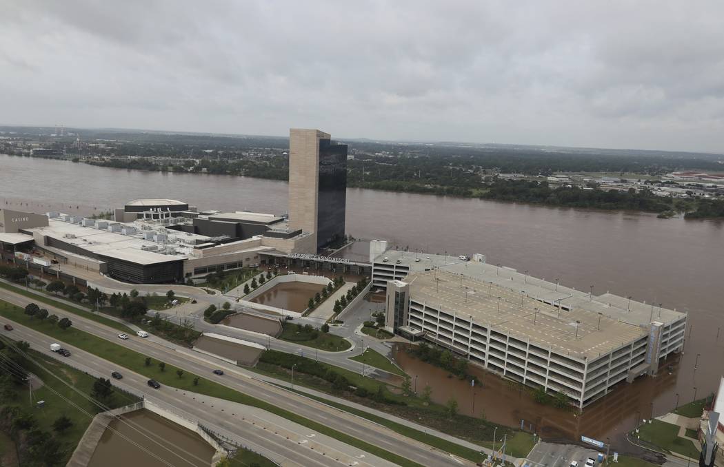 Floodwaters cover the parking area of River Spirit Hotel and Casino on the Arkansas River on Fr ...