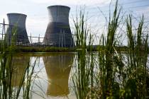 FILE - In this Wednesday, Sept. 7, 2016 file photo, two cooling towers can be seen in the refle ...