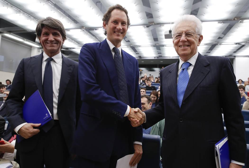 FCA Chairman John Elkann, center, shakes hands with former Italian Premier Mario Monti, right, ...