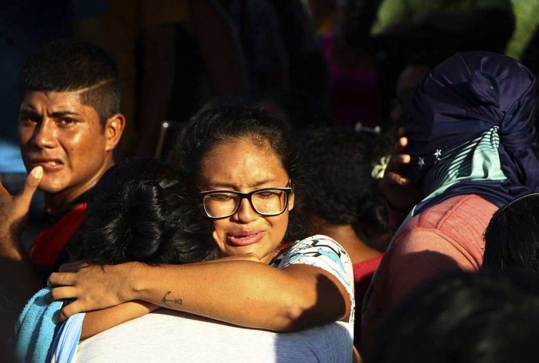 Women embrace outside Anisio Jobim Prison Complex after a deadly riot erupted among inmates in ...