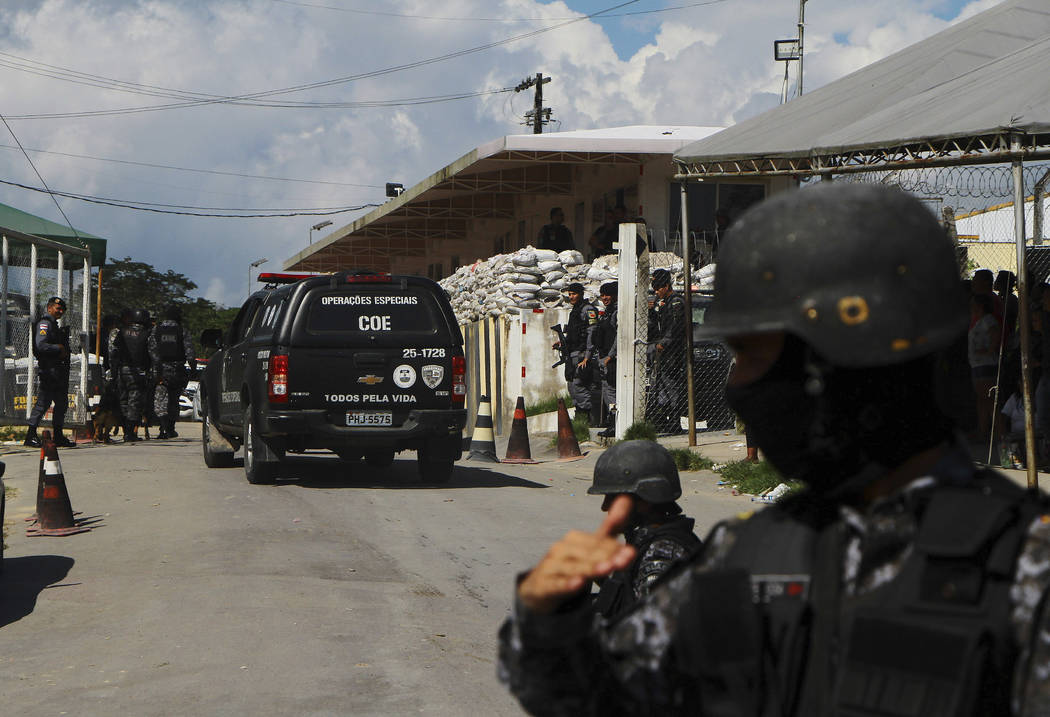 Police guard the entrance to the Anisio Jobim Prison Complex after a deadly riot erupted among ...