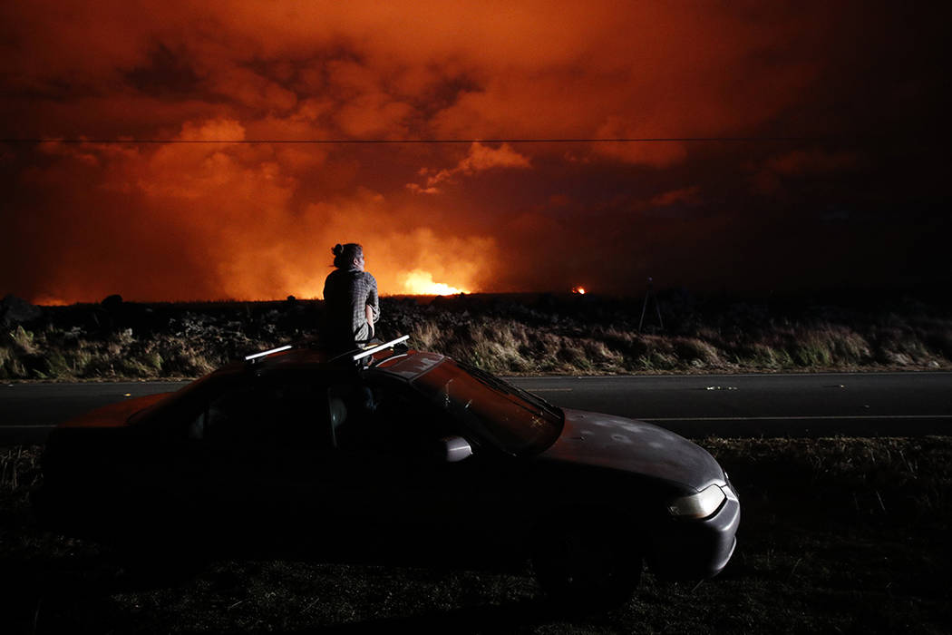 FILE - In this May 19, 2018 file photo, Brittany Kimball watches as lava erupts from a fissure ...