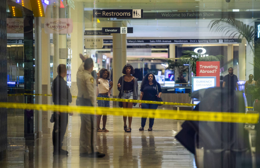 An LVMPD crime scene investigator and officer direct individuals inside the Fashion Show mall o ...