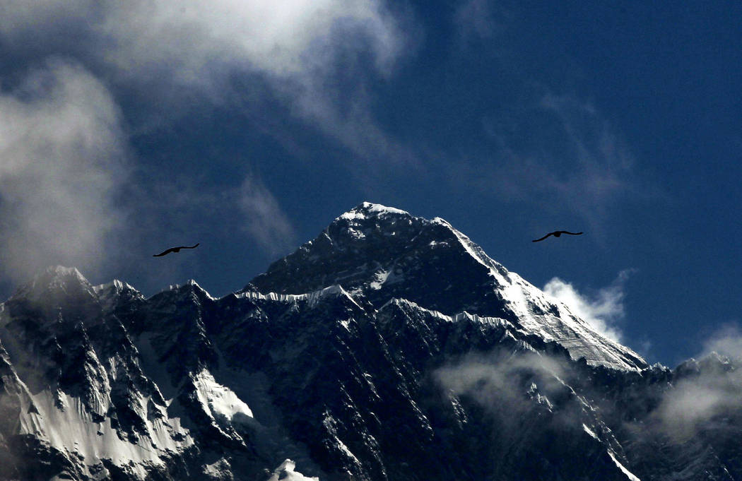 In this Monday, May 27, 209, photo, birds fly as Mount Everest is seen from Namche Bajar, Soluk ...