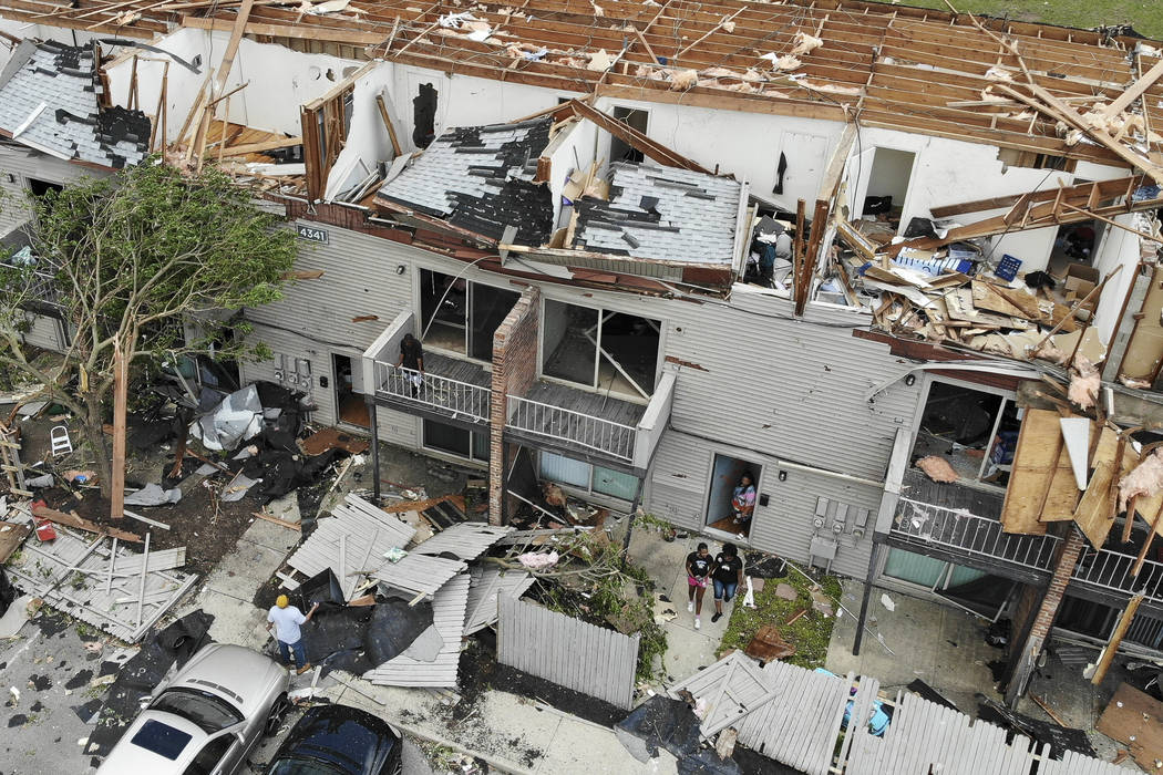 Residents and visitors walk through debris at the River's Edge apartment complex, Tuesday, May ...