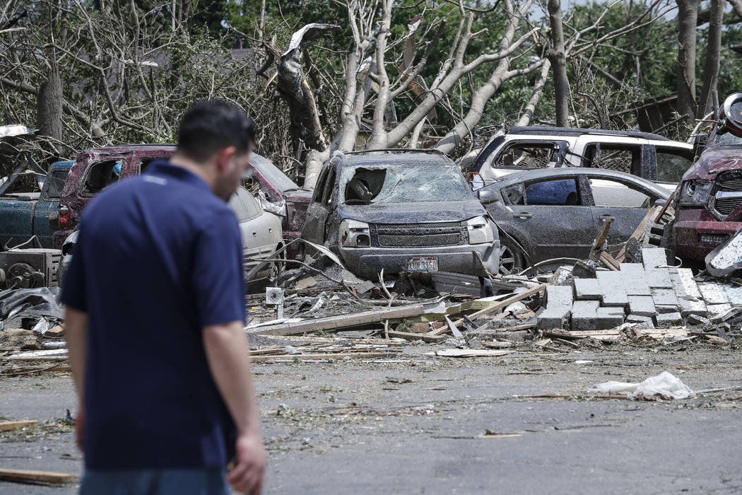 Pedestrians pass along storm debris on North Dixie Drive, Tuesday, May 28, 2019, in Dayton, Ohi ...