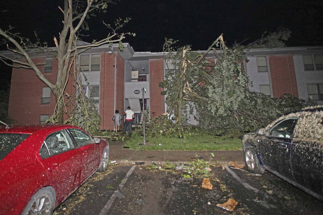 Residents walk toward their Westbrooke Village Apartment building that was heavily damaged by a ...