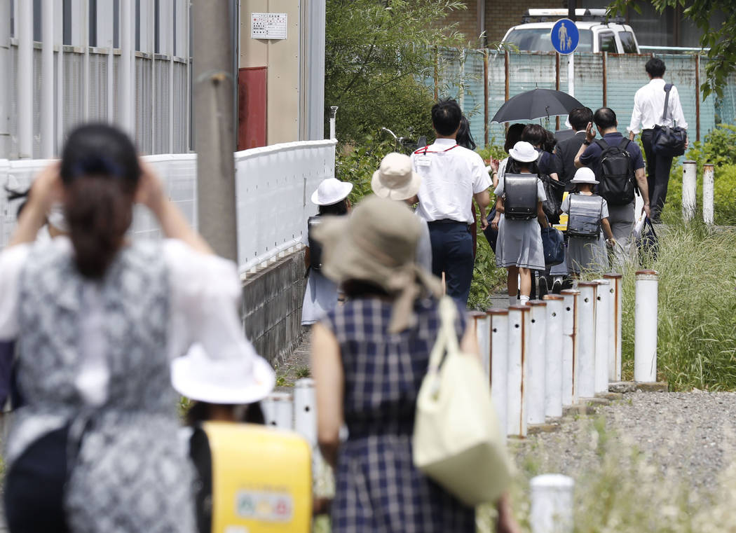 CARITAS Elementary School students leave their school with parents following an attack in Kawas ...