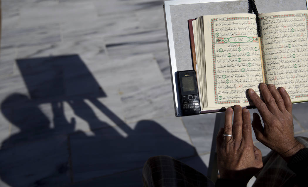 FILE - In this May 8, 2019 file photo, a Palestinian reads verses of the Quran, Islam's holy bo ...